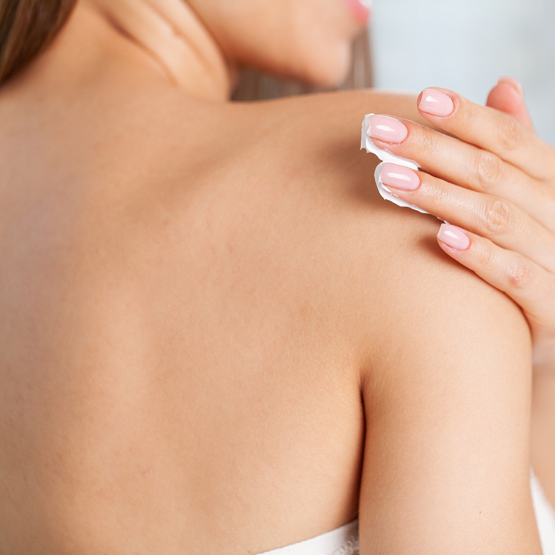 Frau cremt Schulter ein – sanfte Körperpflege als Teil der täglichen Hautroutine mit dem Neosino Tagespflege-Set